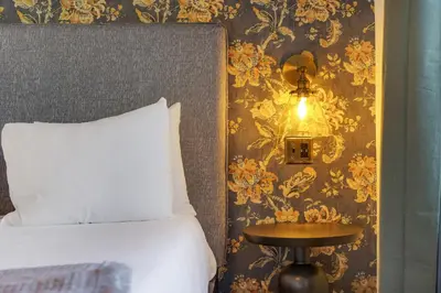a bedroom with a bed and a side table with a lamp at Tower Hotel Little Havana in Miami