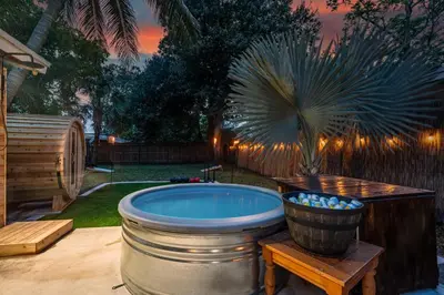 a hot tub in a backyard with a palm tree at Zen Retreat - Sauna Pool Cold Plunge & More in Fort Lauderdale