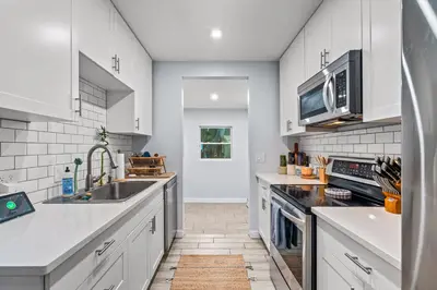 a kitchen with white cabinets and a sink at Zen Retreat - Sauna Pool Cold Plunge & More in Fort Lauderdale