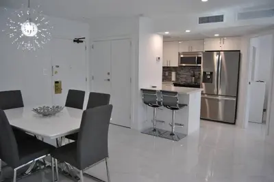a kitchen with a table and chairs and a refrigerator at Luxury Beachfront 3 Bedroom Miami Beach Condo, in Miami Beach