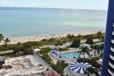 a view of the beach from the balcony of a resort at Luxury Beachfront 3 Bedroom Miami Beach Condo, in Miami Beach