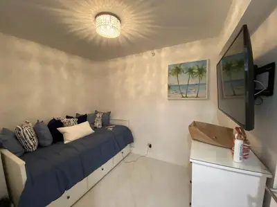 a bedroom with a bed and a flat screen tv at Luxury Beachfront 3 Bedroom Miami Beach Condo, in Miami Beach