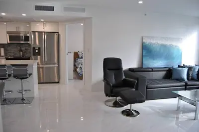 a living room with a black couch and a table at Luxury Beachfront 3 Bedroom Miami Beach Condo, in Miami Beach