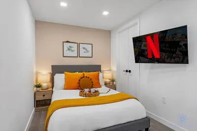 a bedroom with a large bed with orange pillows at Beautiful Studio Amazing Pool Gym Bar and Spa in Miami