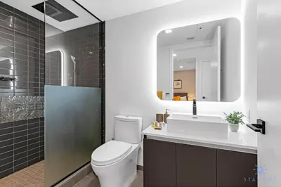 a bathroom with a toilet and a sink and a mirror at Beautiful Studio Amazing Pool Gym Bar and Spa in Miami