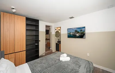 a bedroom with a large bed with a wooden cabinet at Luxury RiverFront By Renzzi in Miami