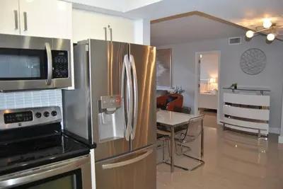 a kitchen with a stainless steel refrigerator and a table at Beach Front Resort - 2 Bedroom, 2 bathrooms, Sleeps 6, 2 Pools- at The Alexander in Miami Beach