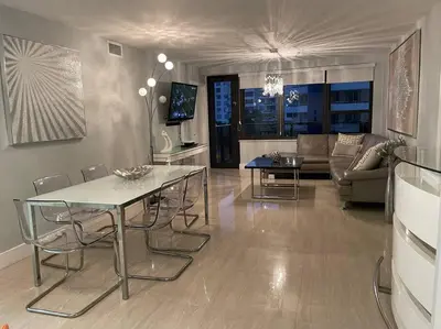 a living room with a table and chairs and a couch at Beach Front Resort - 2 Bedroom, 2 bathrooms, Sleeps 6, 2 Pools- at The Alexander in Miami Beach