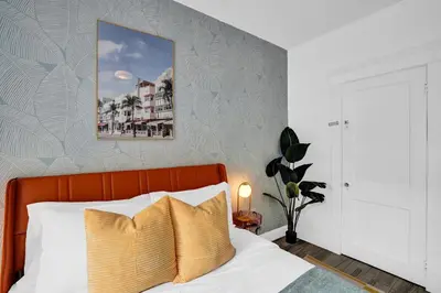 a bedroom with a bed with a orange headboard at 5 Mins Brickell - Pool & Billiards - Retro Miami in Miami