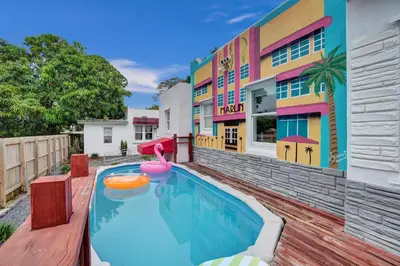 a pool in front of a house with a pink flamingo at 5 Mins Brickell - Pool & Billiards - Retro Miami in Miami