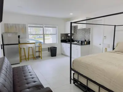 a bedroom with a bed and a kitchen with a counter at New Mid Miami Beach apt free parking and beach access in Miami Beach