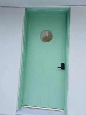 a green door with a window in a building at New Mid Miami Beach apt free parking and beach access in Miami Beach