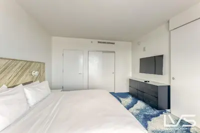 a white bedroom with a bed and a television at W FTL 1409 Beachfront Resort 2 Bedroom & 2 Bathroom Condo in Fort Lauderdale