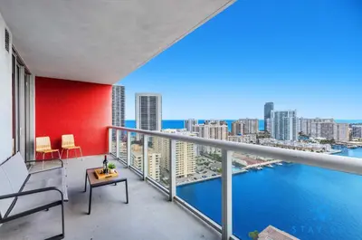 a balcony with a view of the city and the water at Infinite View Amazing Apt Spectacular Amenities in Hallandale Beach