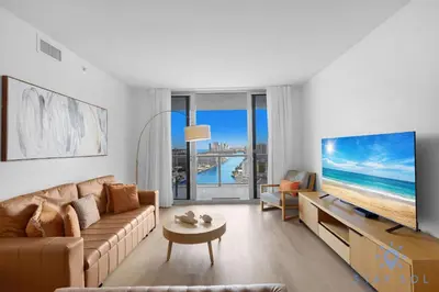 a living room with a couch and a large screen tv at Spectacular Apt Infinity View Amazing Amenities in Hallandale Beach