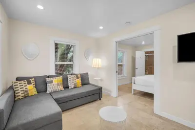 a living room with a couch and a bedroom at Renovated Grove Bungalow -near Coconut Grove in Miami