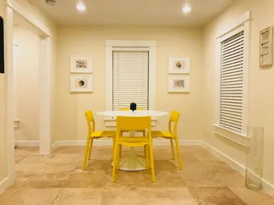 a dining room with a yellow table and chairs at Renovated Grove Bungalow -near Coconut Grove in Miami