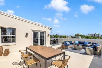 a patio with a wooden table and chairs on a roof at Gorgeous coastal PH with Large Private Terrace in Miami Beach