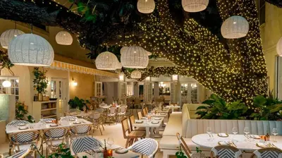 a restaurant with white tables and chairs and lights at Gorgeous coastal PH with Large Private Terrace in Miami Beach