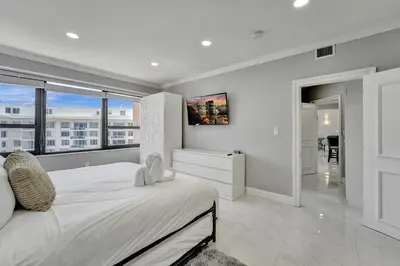 a white bedroom with a large bed and a large window at Luxury Penthouse 3BR 3BA Oceanfront PH7 in Miami Beach