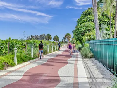 a group of people riding bikes down a path at Luxury Penthouse 3BR 3BA Oceanfront PH7 in Miami Beach