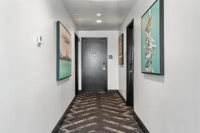 a hallway with a door and paintings on the walls at Luxuri Suites in Miami Beach