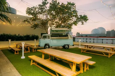 a picnic area with benches and a van with a grill at Flow Hotel Miami in Miami