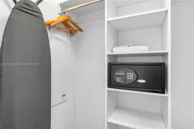 a surfboard and a tv in a white closet at Beautiful 2BR Balcony Pool Near Beach & Fun in Hallandale Beach