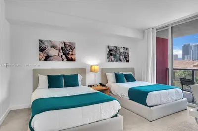 two beds in a hotel room with a window at Amazing Studio Spectacular Amenities Near Beach in Hallandale Beach