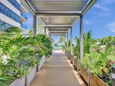a walkway with palm trees and a building at High Floor Miami Beach Pool Beach Service 1219 in Miami Beach