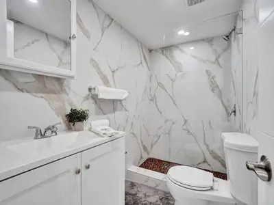 a white bathroom with a marble wall at High Floor Miami Beach Pool Beach Service 1219 in Miami Beach