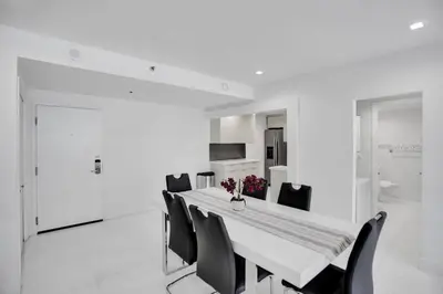 a white dining room with a table and chairs at High floor 2BD with beach service 1616 in Miami Beach