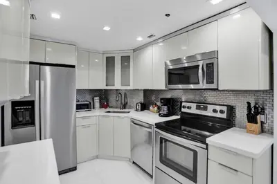 a kitchen with white cabinets and stainless steel appliances at High floor 2BD with beach service 1616 in Miami Beach
