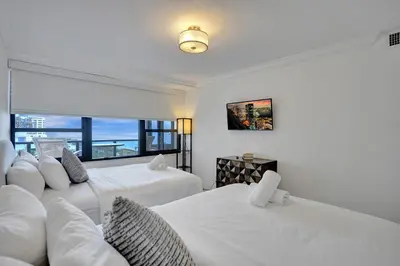 two white beds in a room with a window at Adorable 2 Bedroom Condo Beach Service 904 in Miami Beach
