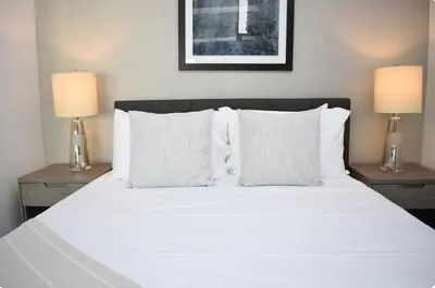a bedroom with a white bed with two lamps at The Bayfront V in Miami