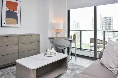 a living room with a bed and a table and a desk at The Bayfront V in Miami