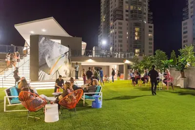 a group of people sitting in chairs in a park at night at The Bayfront V in Miami