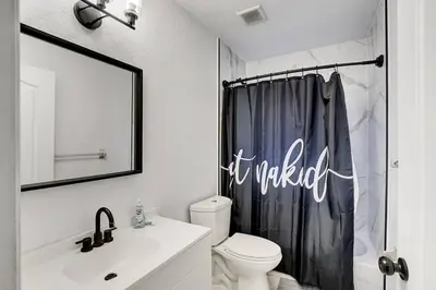 a bathroom with a toilet and a shower curtain at Modern Miami House 2Baths Design District in Mins in Miami
