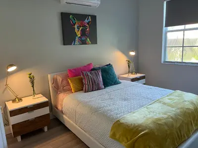 a bedroom with a bed with colorful pillows at Chic Private Retreat in Homestead