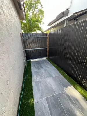 a backyard with a fence and a sidewalk at Chic Private Retreat in Homestead
