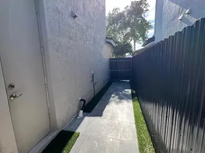 a walkway with a fence next to a building at Chic Private Retreat in Homestead