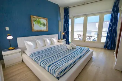 a bedroom with a large bed with a blue wall at King 1 Bed Apt with rooftop pool C202 in Miami Beach