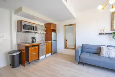 a living room with a blue couch and a kitchen at King Bed-Apt with Rooftop Pool-Bar D303 in Miami Beach