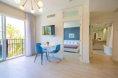 a living room with a table and chairs and a bedroom at King Bed-Apt with Rooftop Pool-Bar D303 in Miami Beach