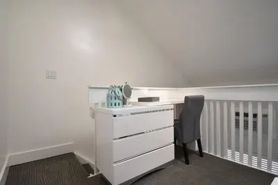a white bedroom with a desk and a chair at Modern Loft wsteps to Beach Kitchenette in Hollywood
