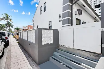a white building with a gate and stairs on a sidewalk at Modern Loft wsteps to Beach Kitchenette in Hollywood
