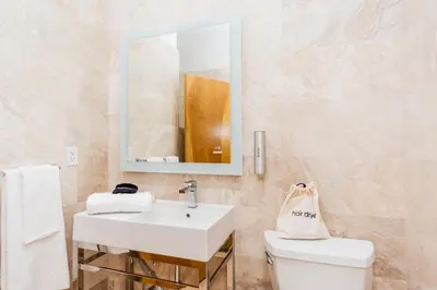 a bathroom with a sink and a toilet and a mirror at The Link Hotel South Beach in Miami Beach