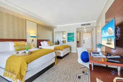 a hotel room with two beds and a desk at Deluxe Studio Balcony Bay View Amazing Pool in Sunny Isles Beach