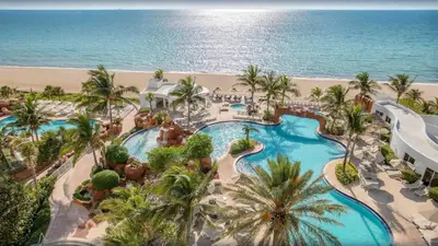 an aerial view of a resort with a pool and the ocean at Deluxe Studio Balcony Bay View Amazing Pool in Sunny Isles Beach