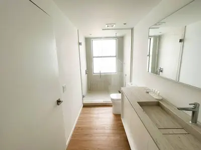a bathroom with a sink and a toilet and a mirror at Beach Haus Design District in Miami